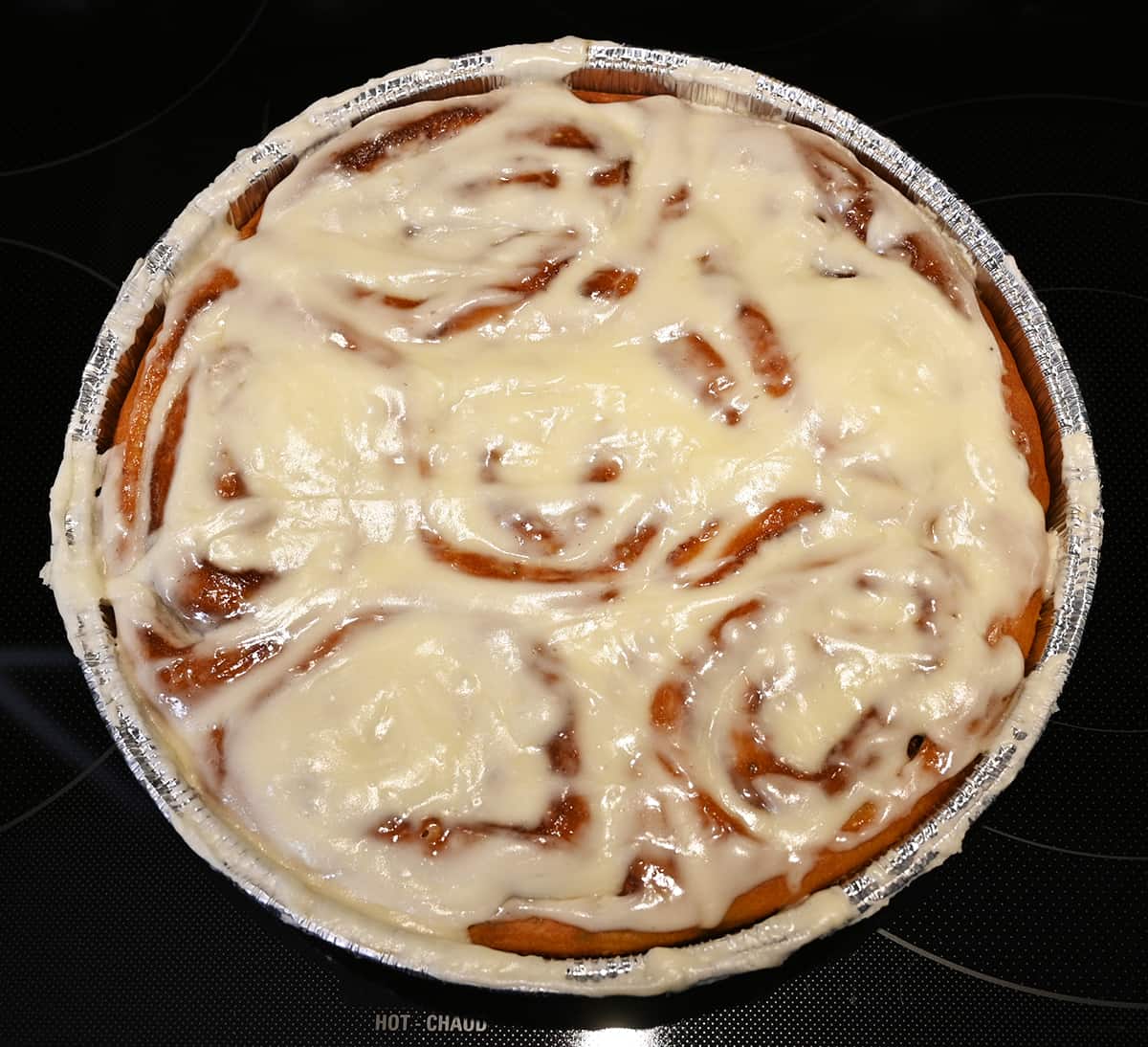 Top down closeup image of the container of cinnamon rolls with the lid off after the rolls have been heated.