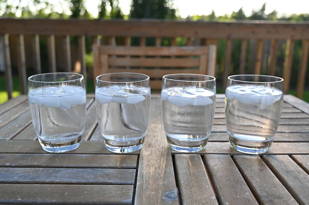 Image of four clear glasses with ice and hard seltzer poured into them. The hard seltzer is clear so looks like water and all four kinds look the same.
