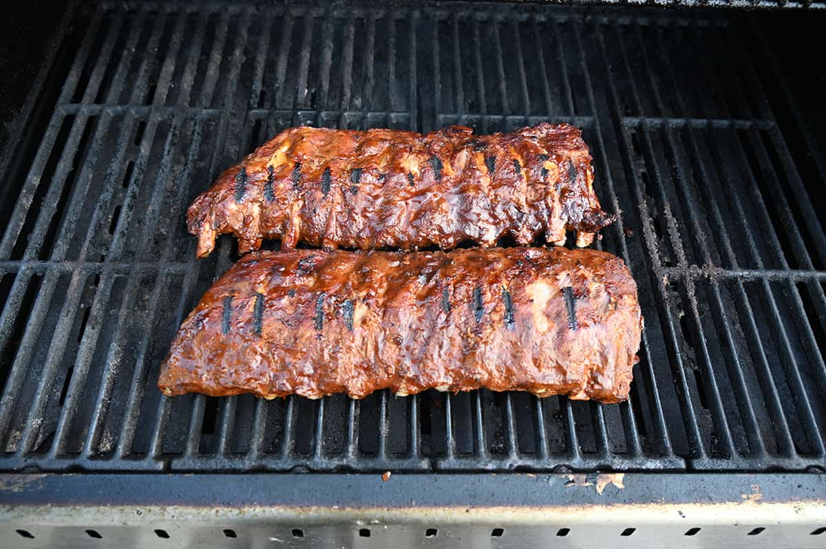 Image of the two racks of ribs grilling on the barbecue.