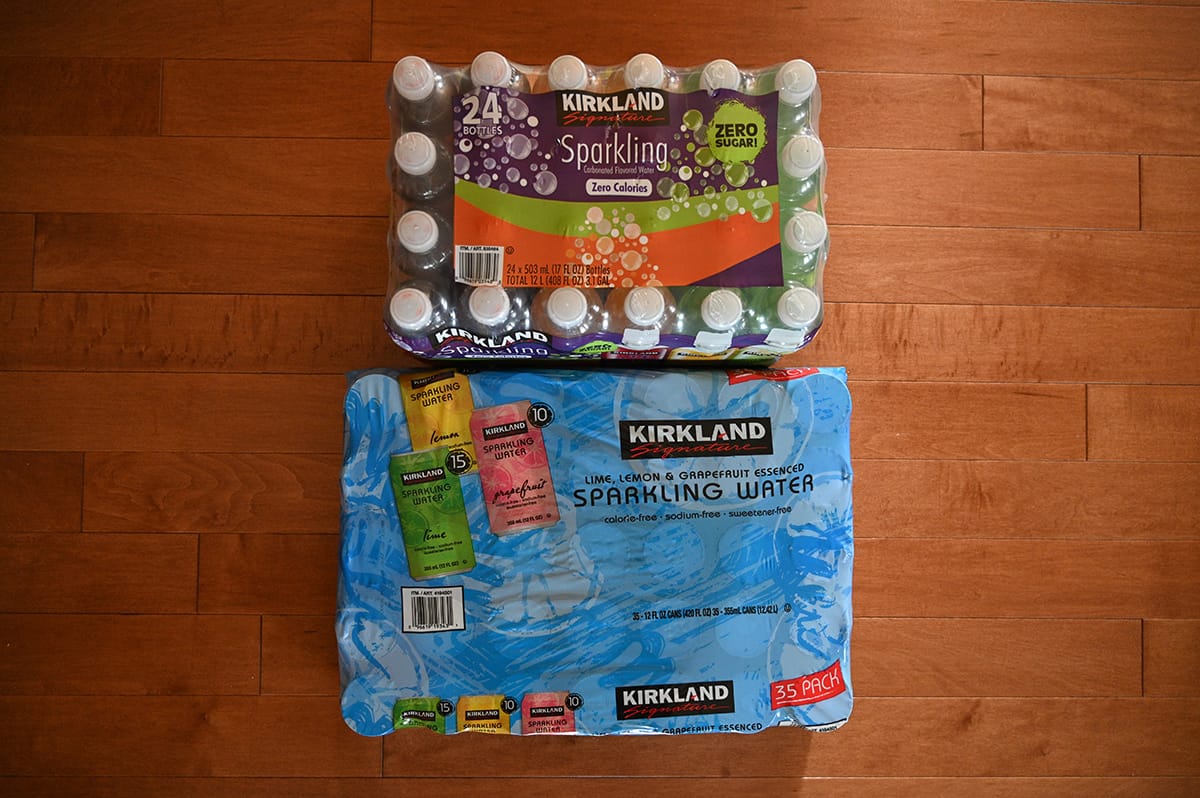 Top down image showing the two cases of sparkling water sitting on a hardwood floor, unopened.