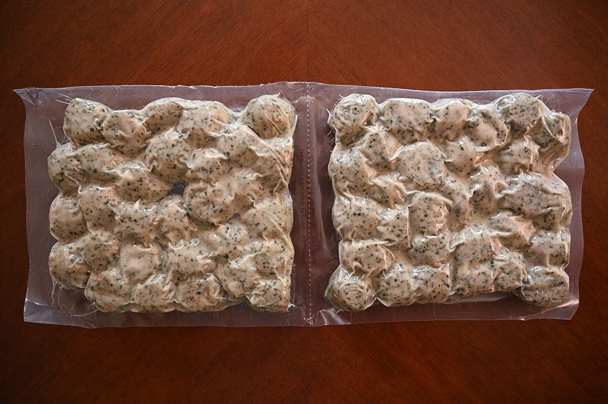 Image of two vacuum-sealed bags of meatballs sitting on a table unopened.
