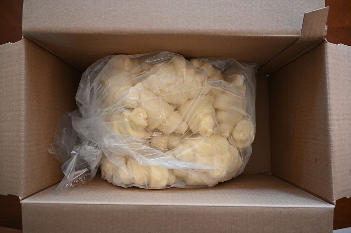 Top down image showing the unbaked croissants wrapped in a bag and all together in a box.