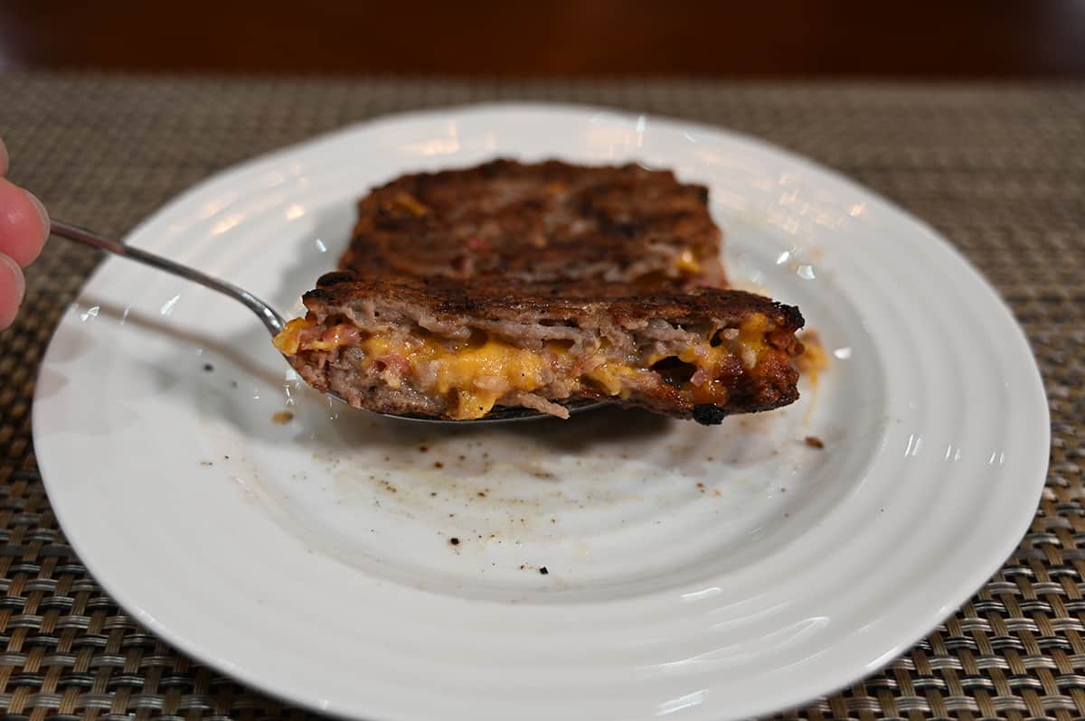 Closeup image of one cheddar & bacon stuffed patty cooked and cut in half so you can see the cheddar and bacon.