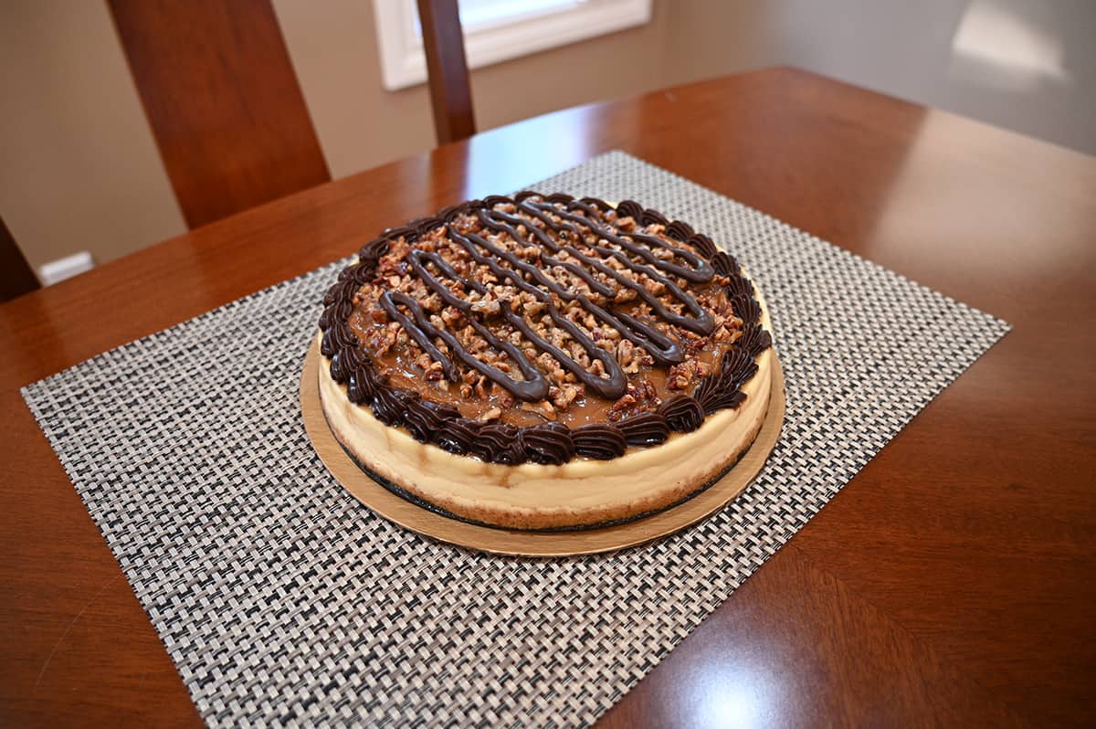 Side view top down image of the cheesecake opened with the lid off sitting on a table ready to slice.