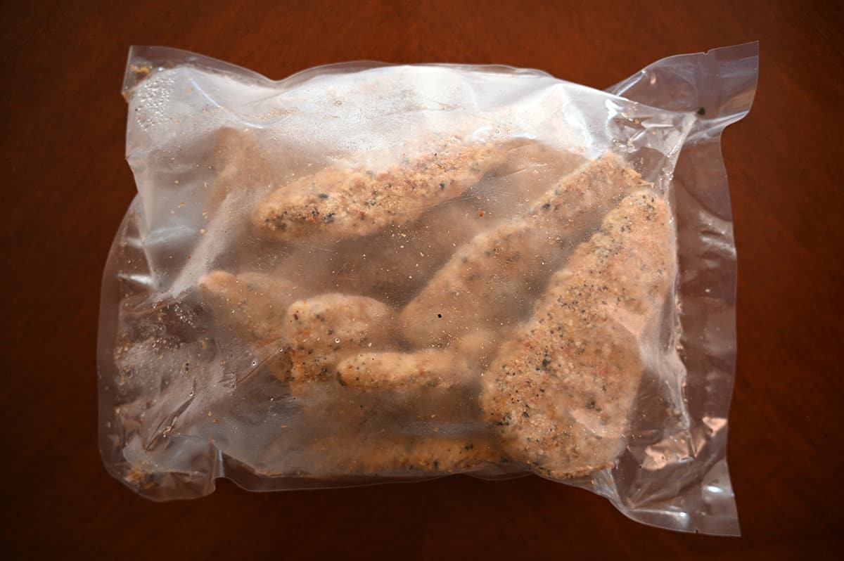 Image of a plastic bag on a table unopened with frozen cod pieces in the bag.