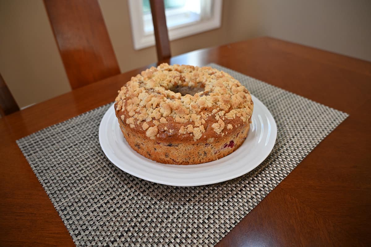 Image of the whole coffee cake unwrapped and sitting on a white plate.