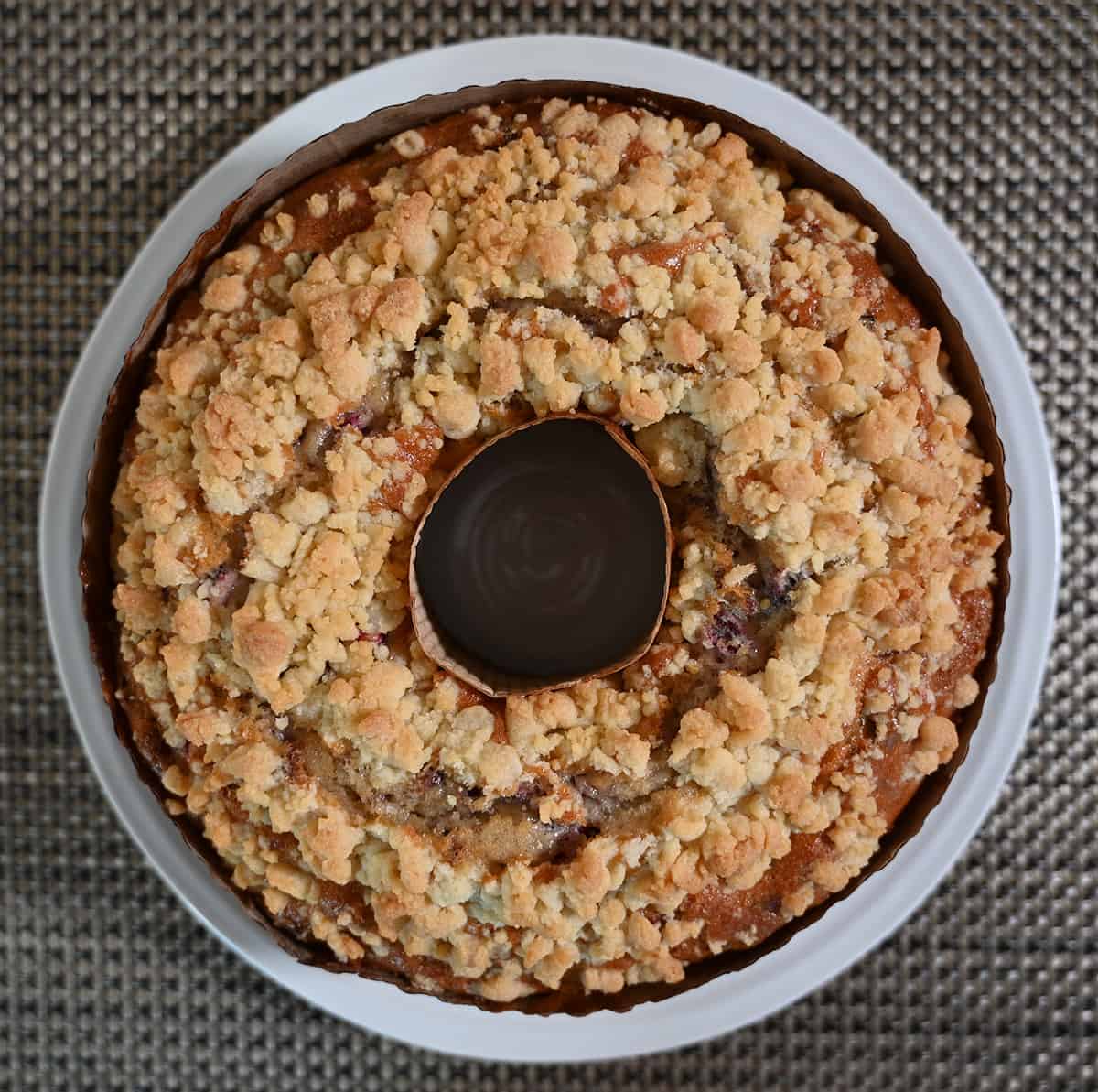 Top down closeup image of the coffee cake sitting on a white plate showing the streusel topping.