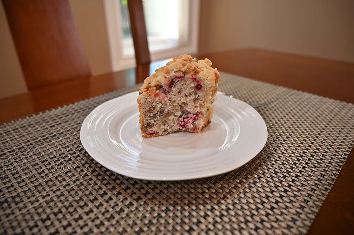 Side view image of a slice of coffee cake served on a white plate.