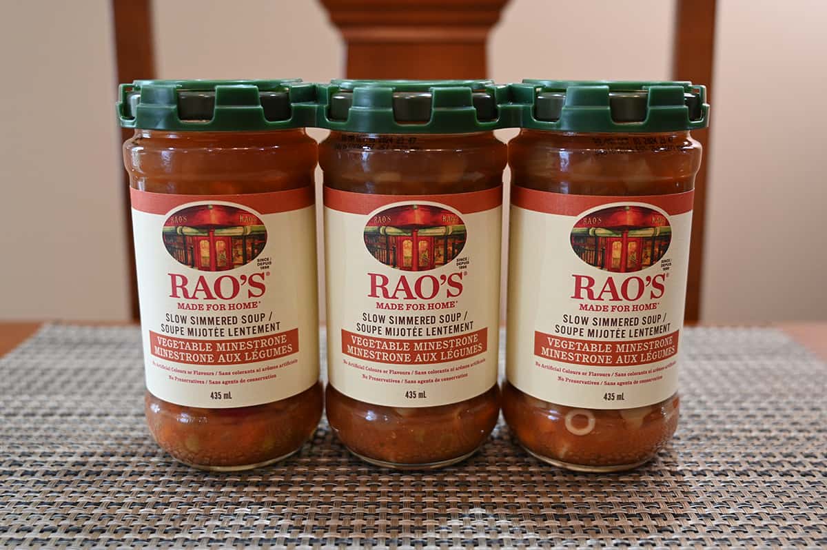 Image of a three-pack of Costco Rao's Vegetable Minestrone Soup sitting on a table unopened.
