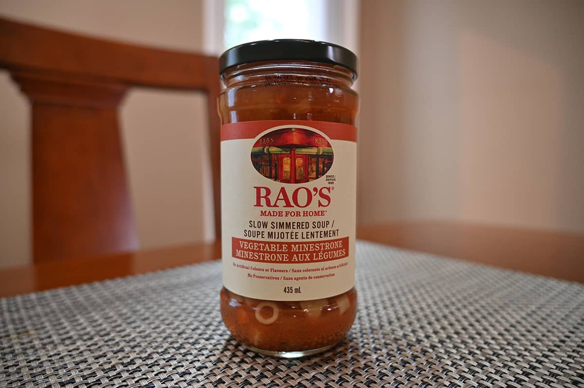 Closeup image of one Rao's Vegetable Minestrone Soup jar sitting on a table.