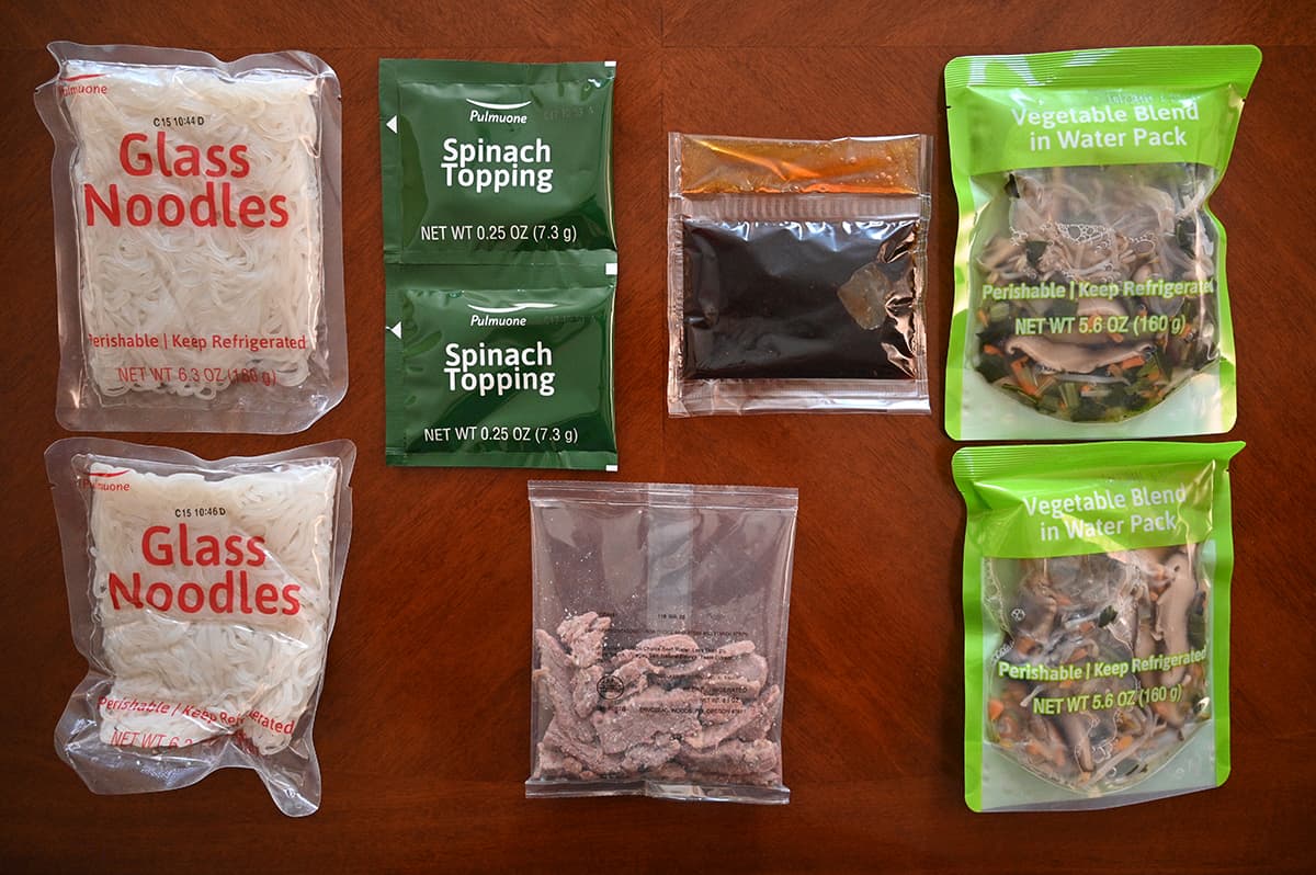 Top down image of all the packets of ingredients that come in the package sitting on top of a table.