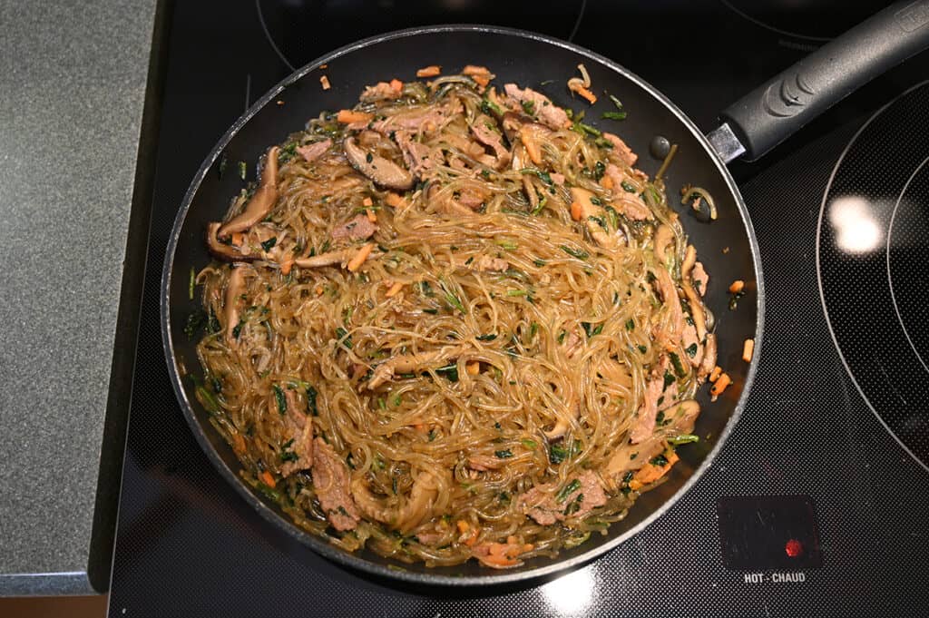 Top down image of the prepared japchae in a pan on the stove.