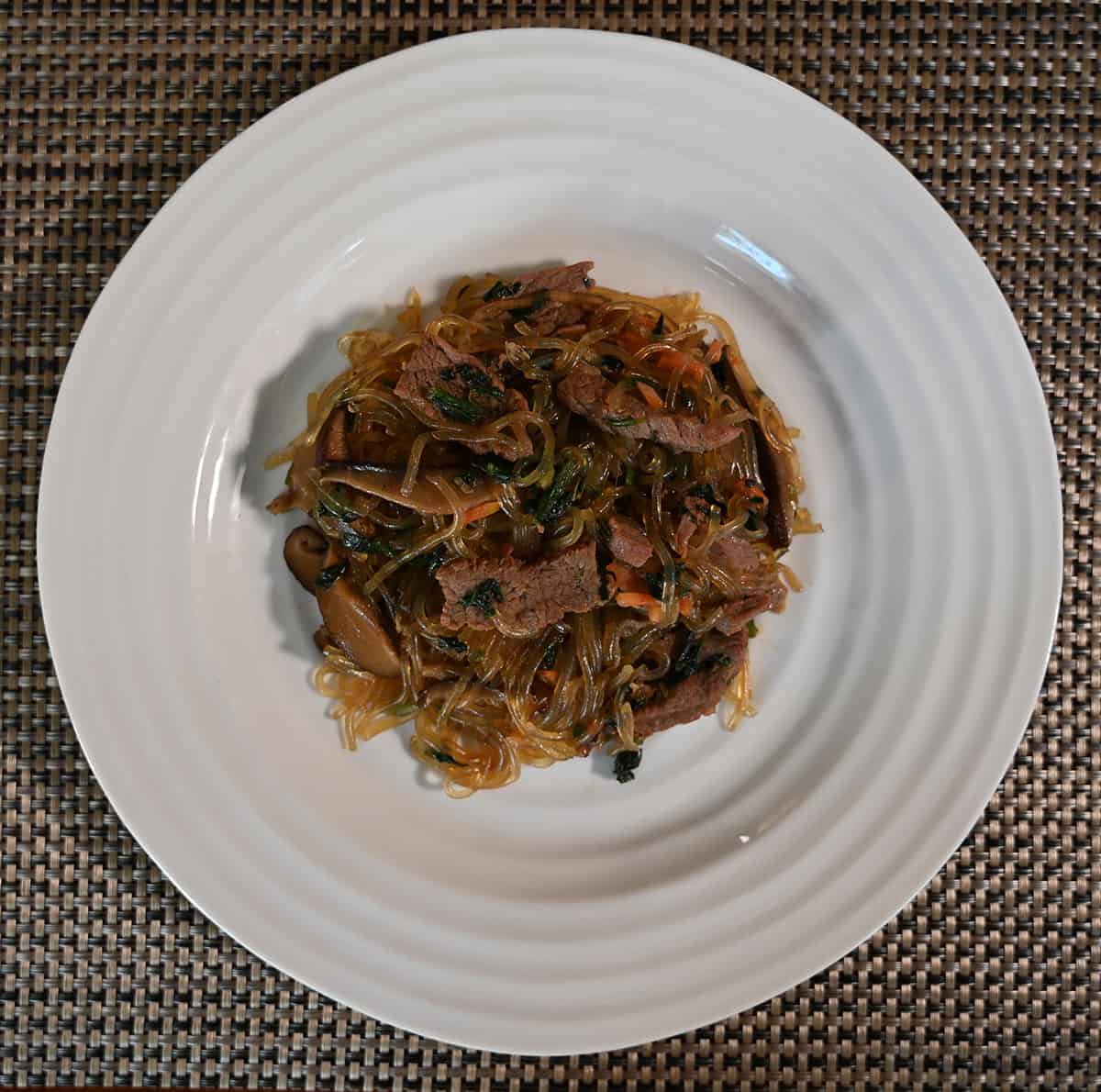 Top down image of the japchae served on a white plate.