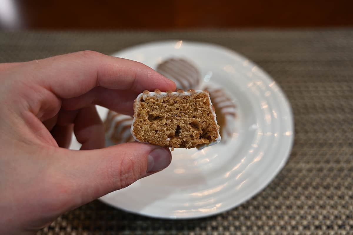 Closeup side view image of a pumpkin spice bite with a bite taken out of it so you can see what the center of the cake looks like.