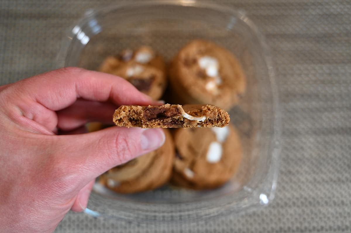 Closeup image of a hand holding one cookie with a few bites taken out of it so you can see what the center looks like.