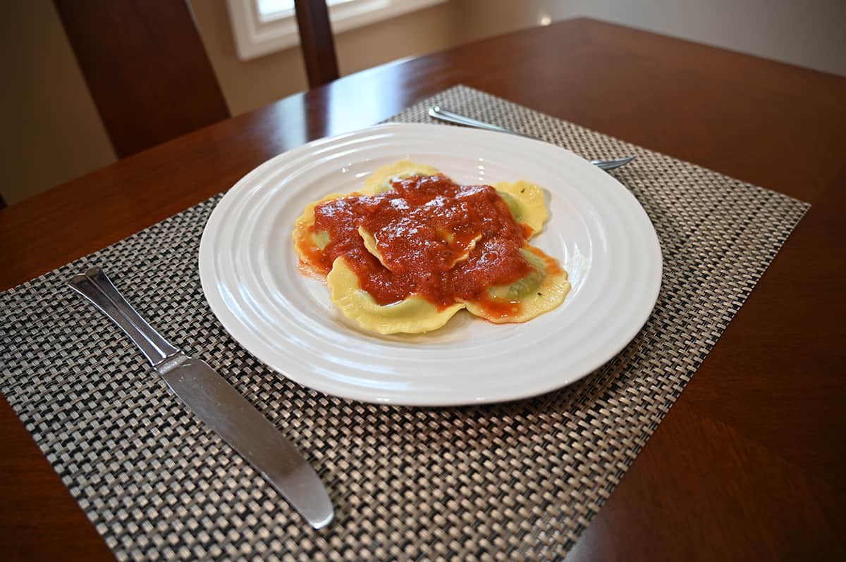 Top down image of plate of prepared ravioli with a red sauce covering the cooked ravioli.