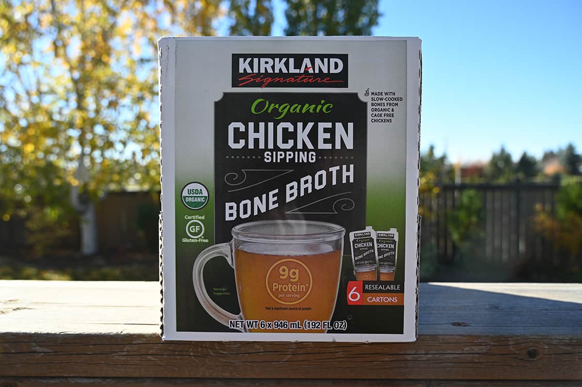 Image of the Costco Kirkland Signature Organ Chicken Bone Broth box sitting on a deck outside unopened.