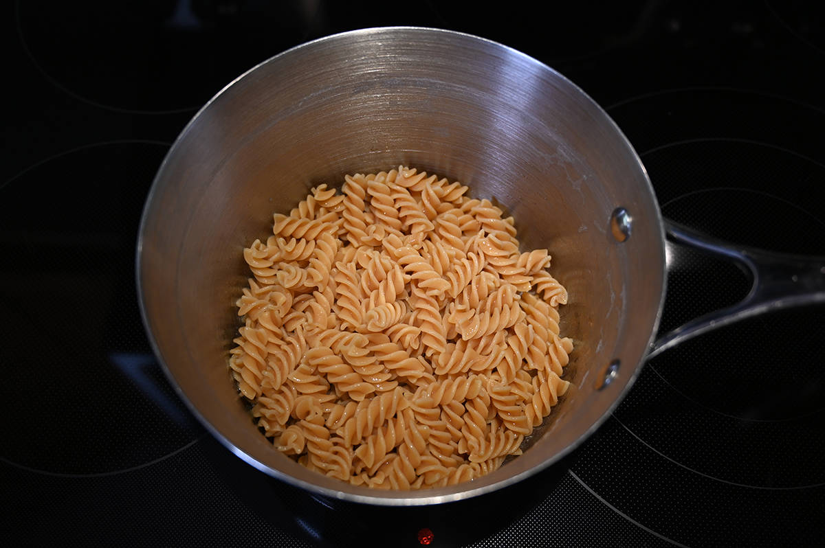 Top down image of a pot of cooked and drained chickpea pasta sitting on a stovetop.