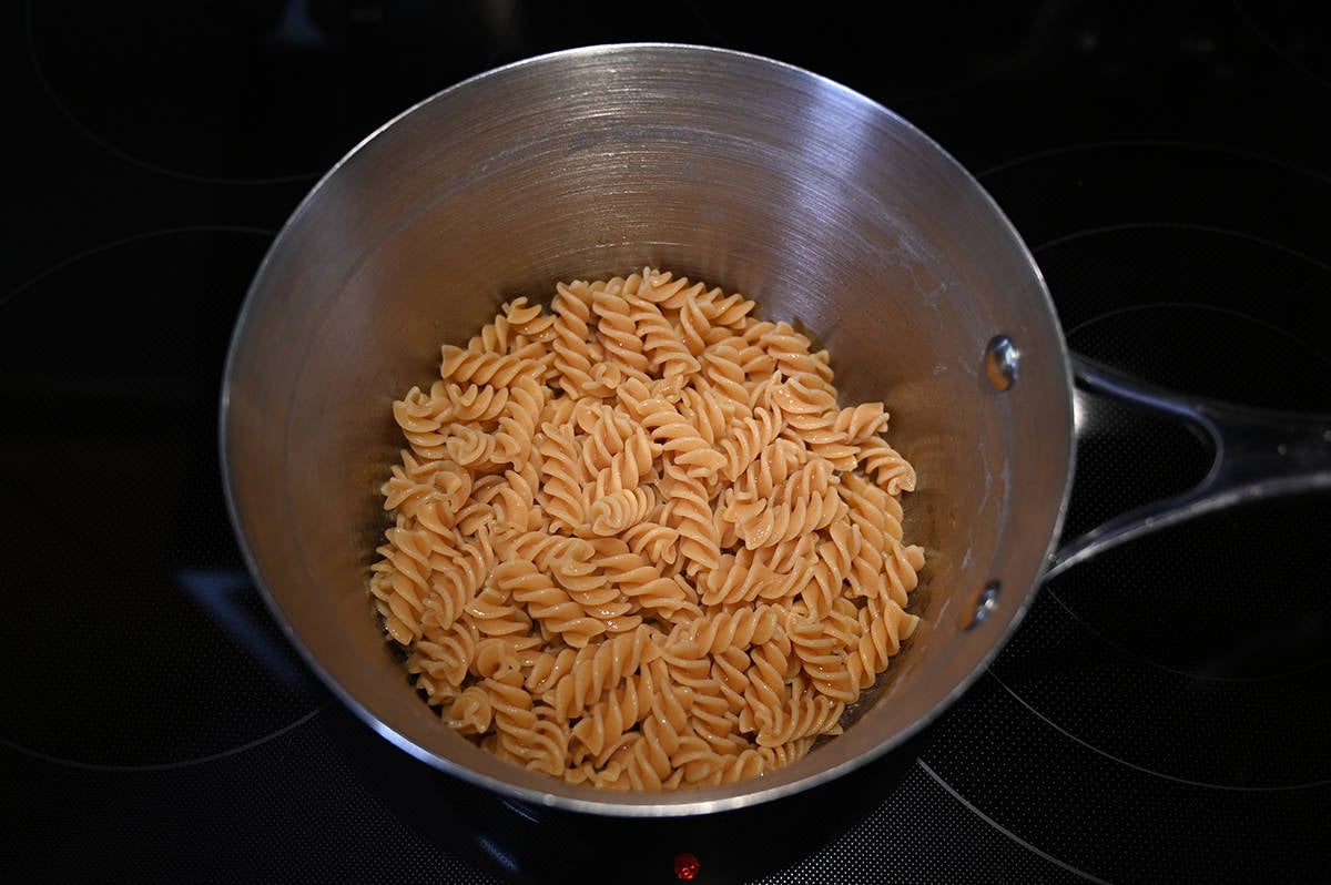 Top down image of a pot of cooked and drained chickpea pasta sitting on a stovetop.