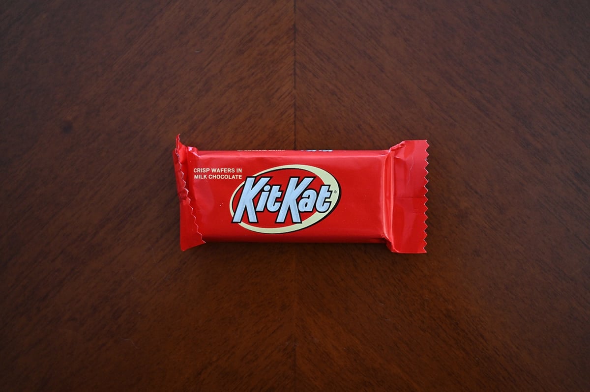 Top down image of an unopened Kit Kat chocolate bar sitting on a table.