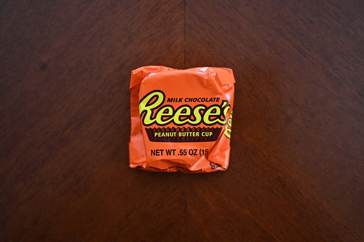 Top down image of an unopened Reese's Peanut Butter Cup sitting on a table.