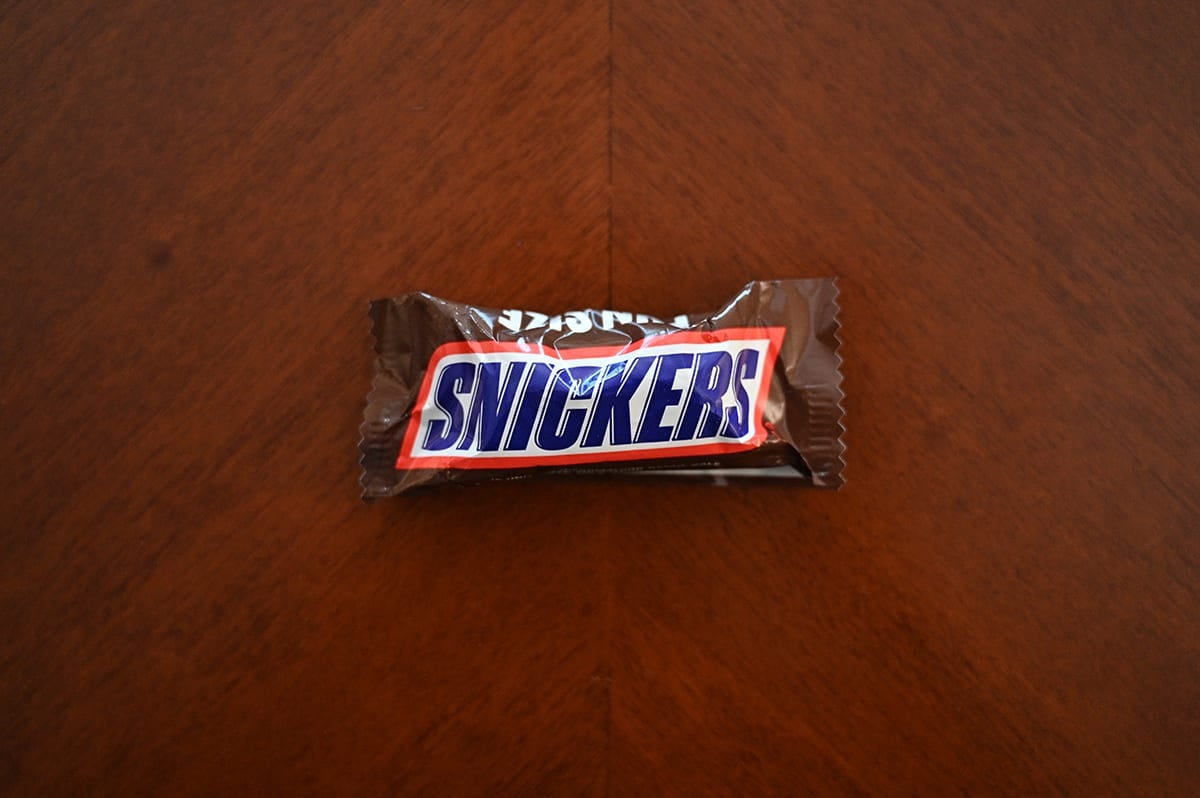 Top down image of a Snickers sitting on a table unopened.