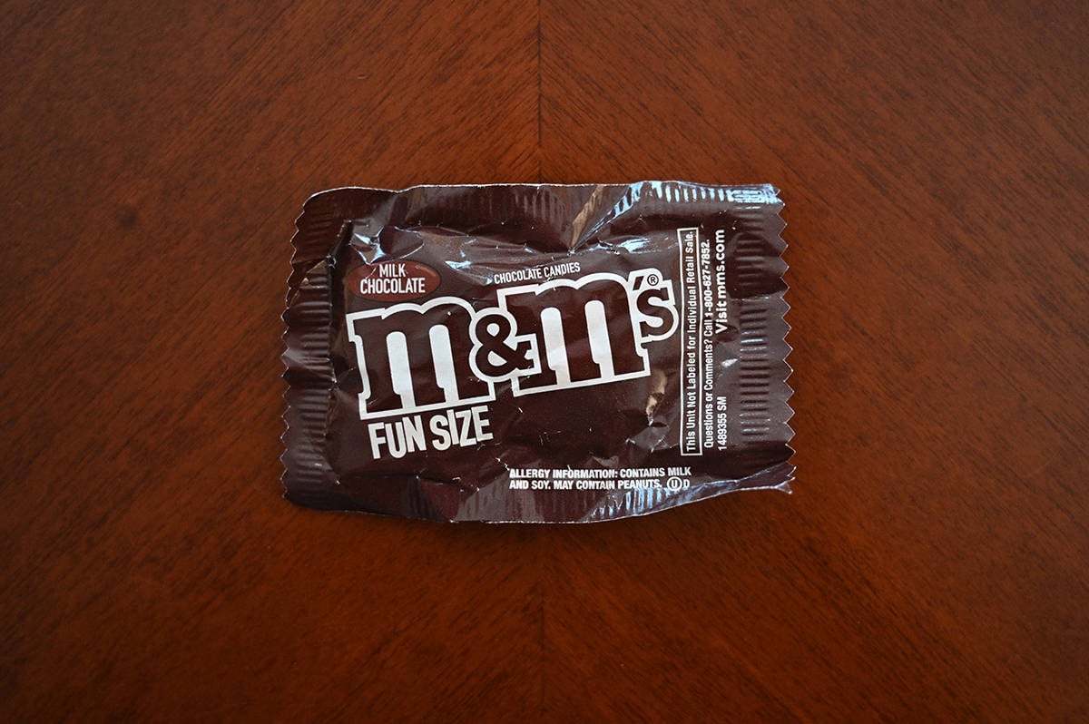 Top down image of a packet of M&M's sitting on a table unopened.