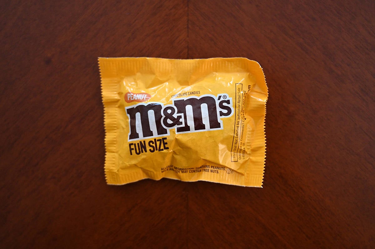 Top down image of a packet of M&M's sitting on a table unopened.