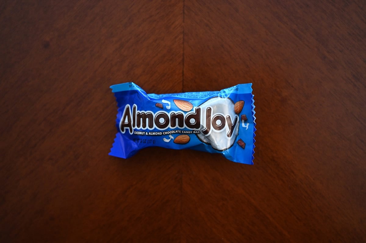 Top down image of an unopened Almond Joy chocolate bar sitting on a table.