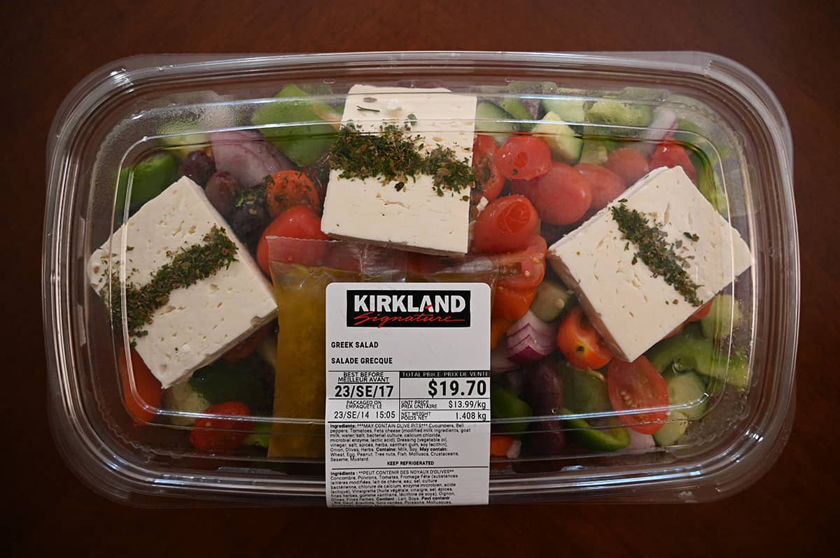 Top down iage of an umnopened Costco Kirkland Signature Greek Salad sitting on a table.