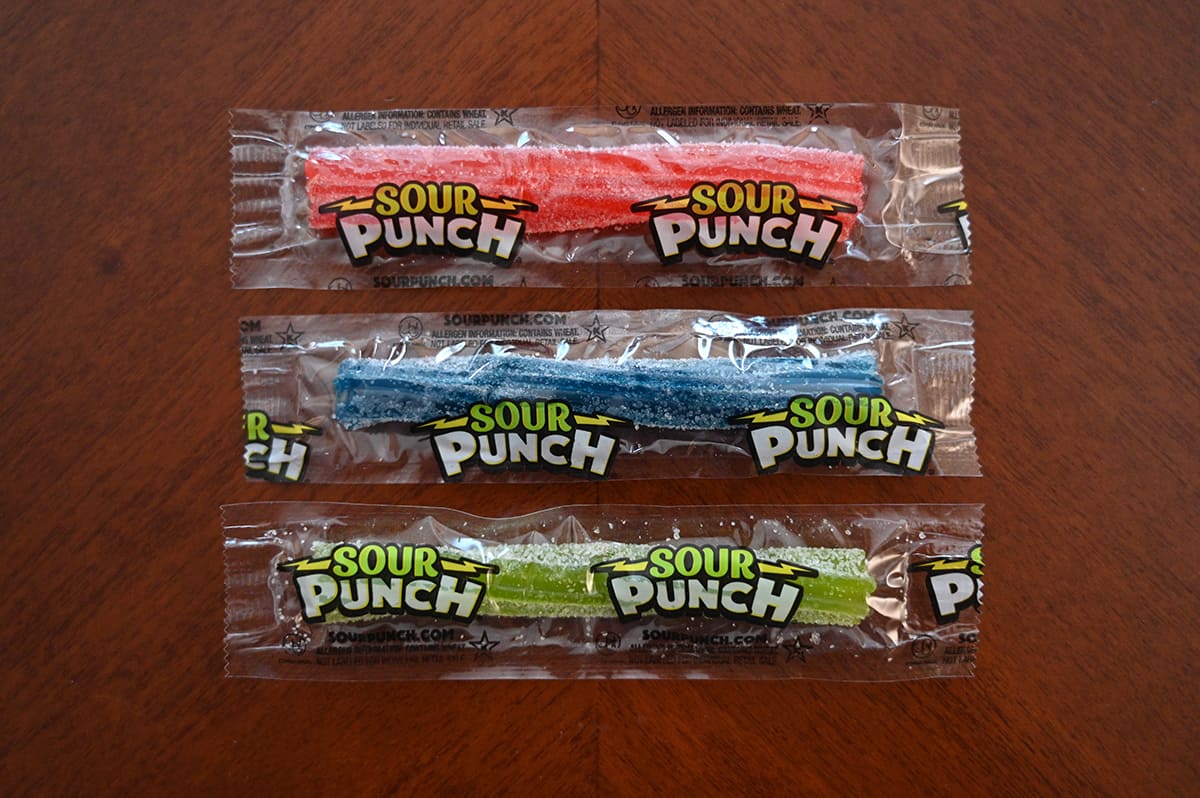 Top down image of three sour punch candies unopened, sitting on a table.
