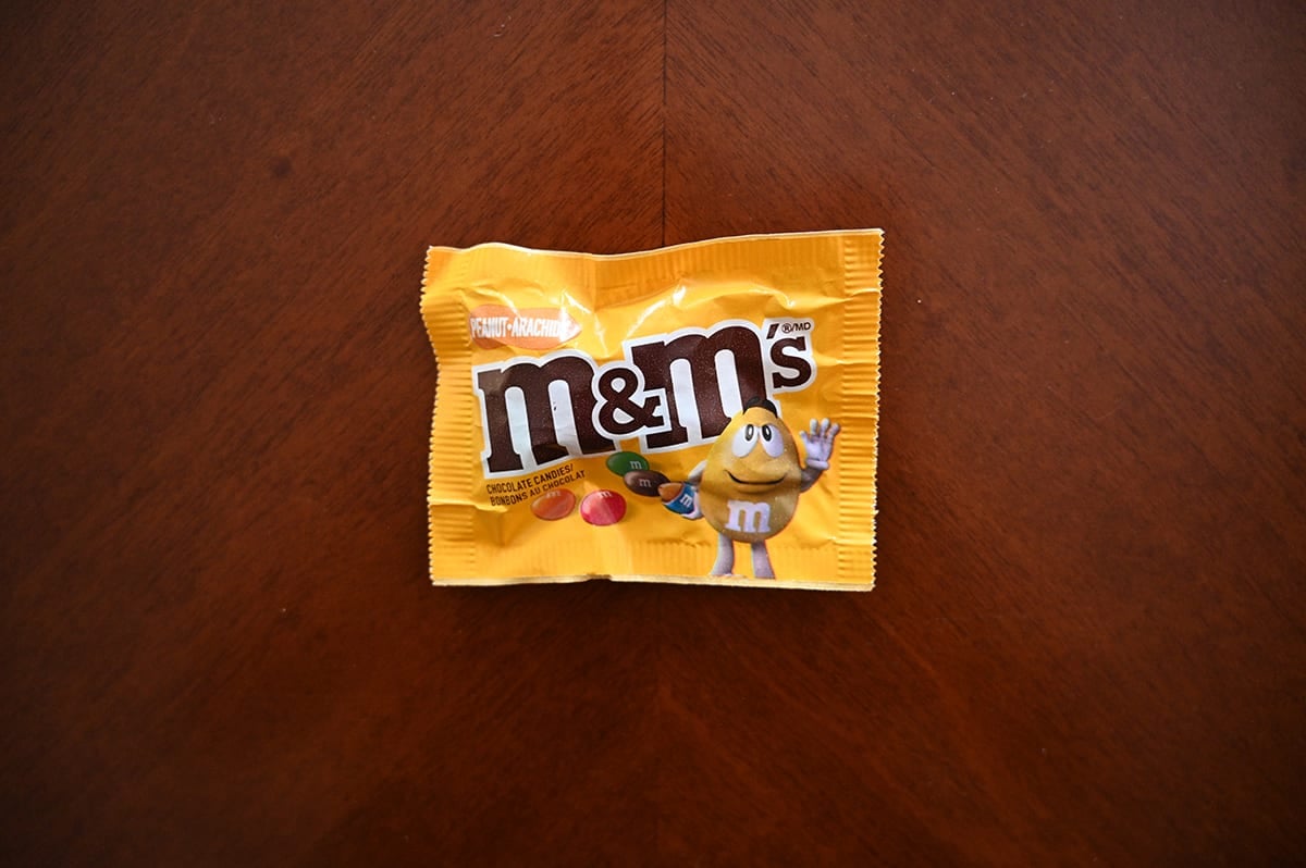 Top down image of a bag of peanut M&M's unopened sitting on a table.