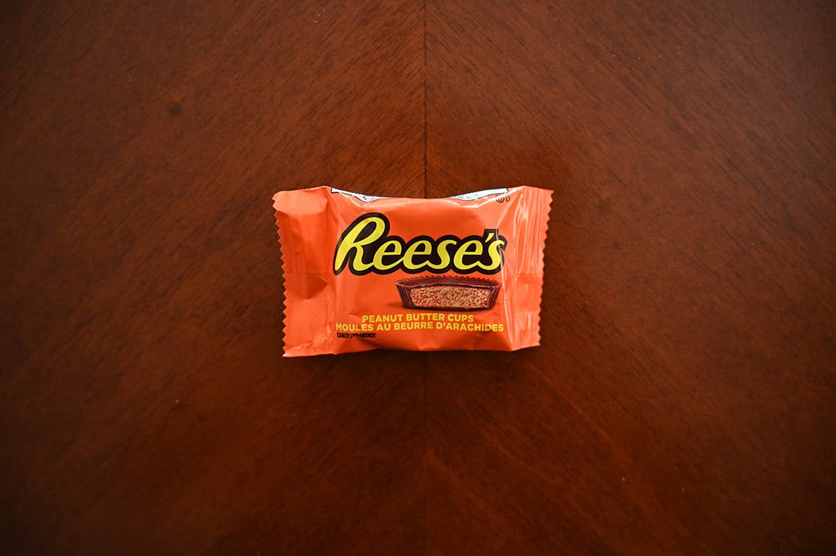 Top down image of a Reese's peanut butter cup, unopened sitting on a table.