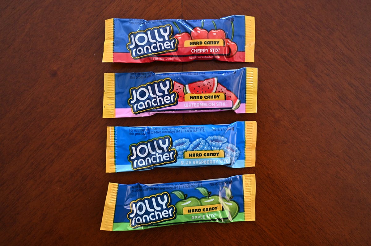 Top down image of three Jolly Rancher Stix sitting on a table unopened. There are three flavors.