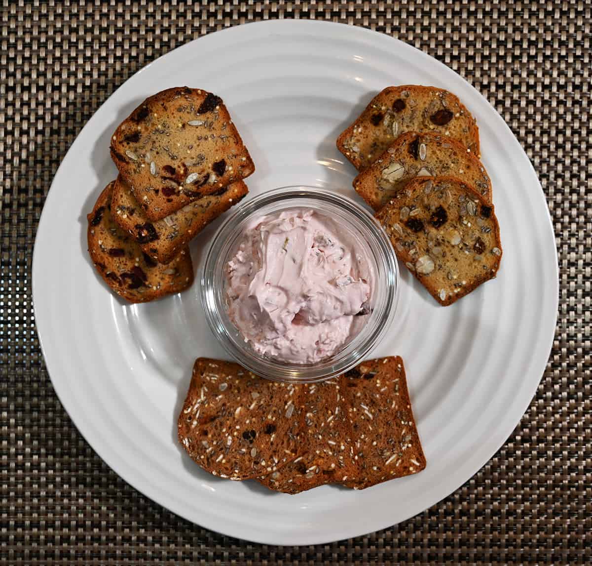 Top down image of a plate of crackers with cranberry jalapeno dip in the middle.