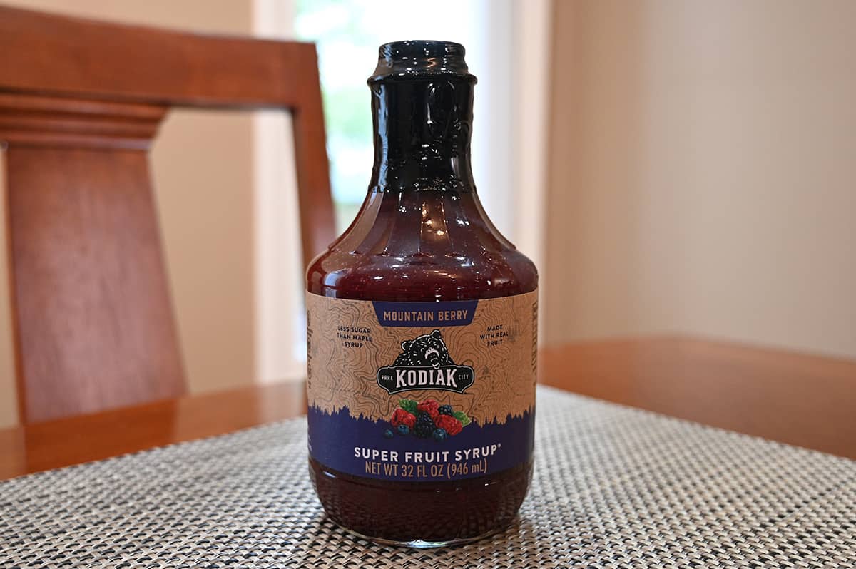 Image of the Costco Kodiak Super Fruit Mountain Berry Syrup unopened bottle sitting on a table.
