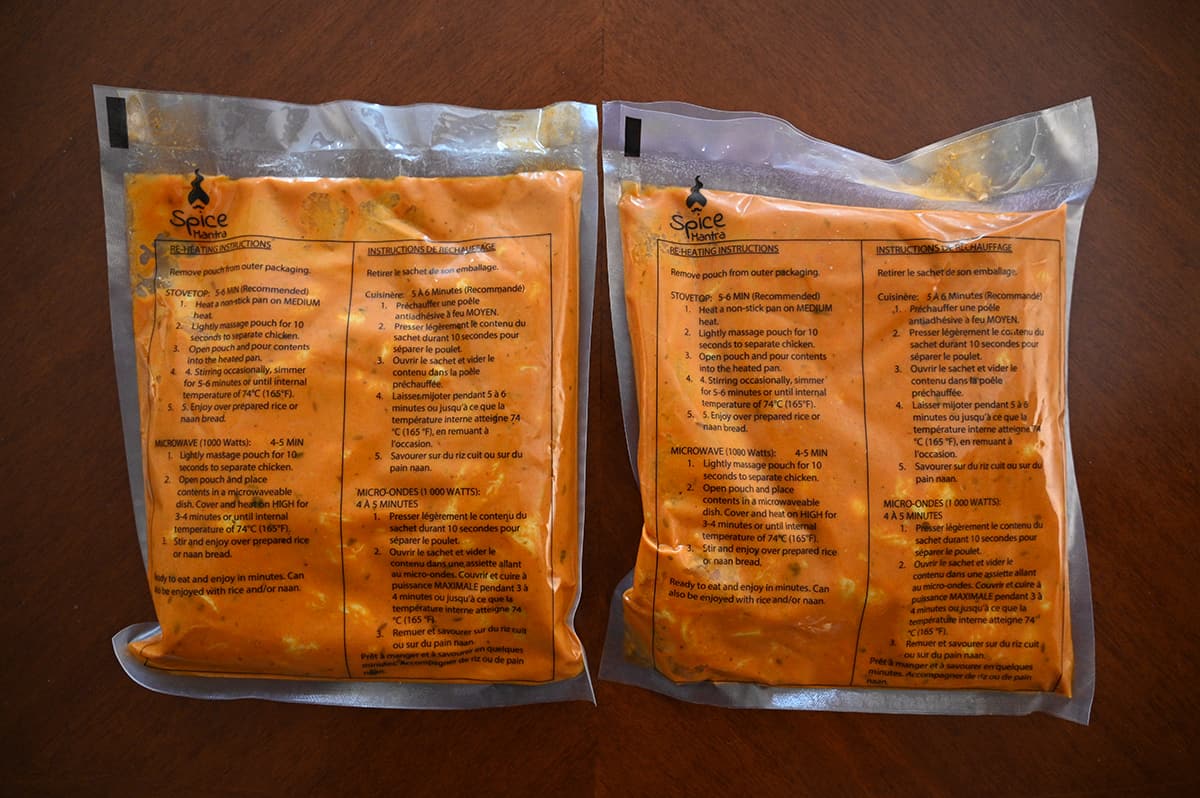 Top down image of two plastic pouches of chicken tikka masala unopened sitting on a table.