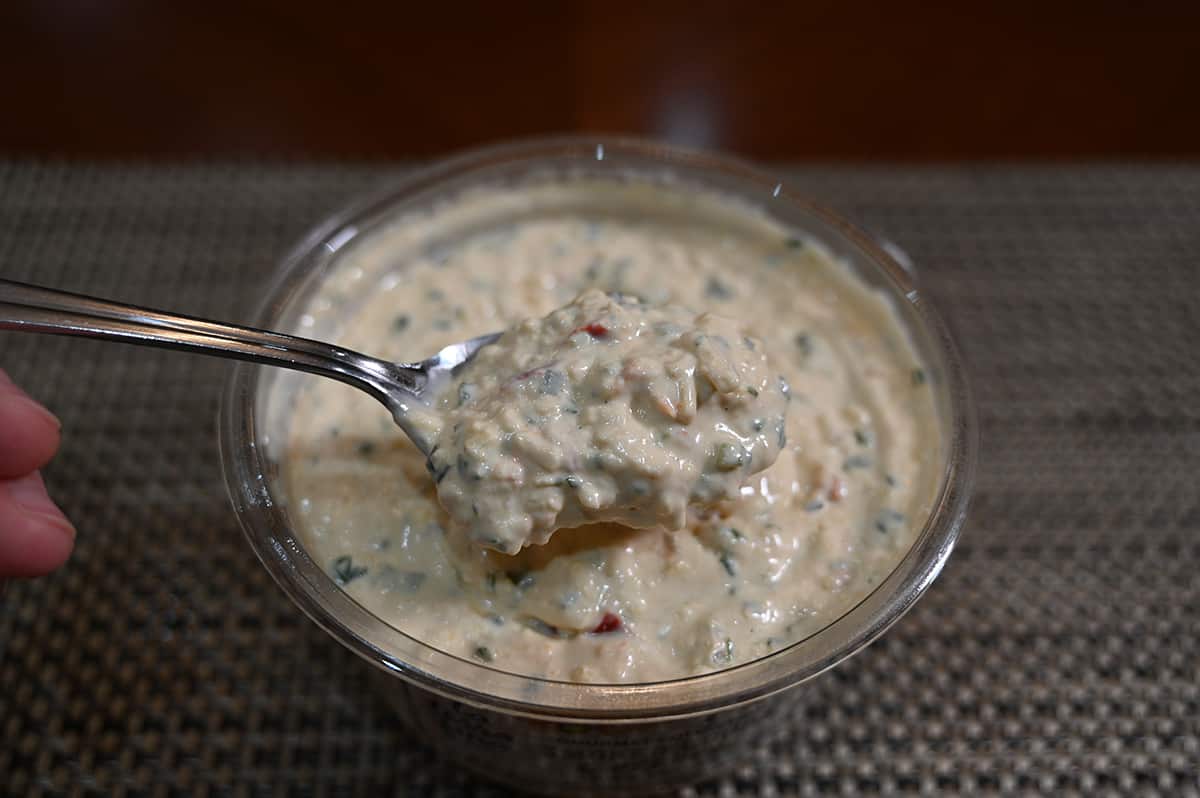 Sideview image of the dip with a spoon hovering over it full of dip.