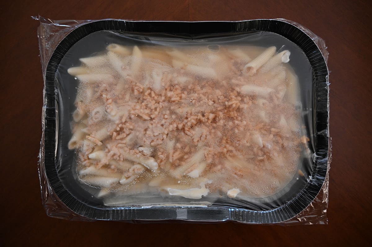 Top down image of the frozen tray of Beecher's Mac and Cheese with the plastic film still on top of the tray.