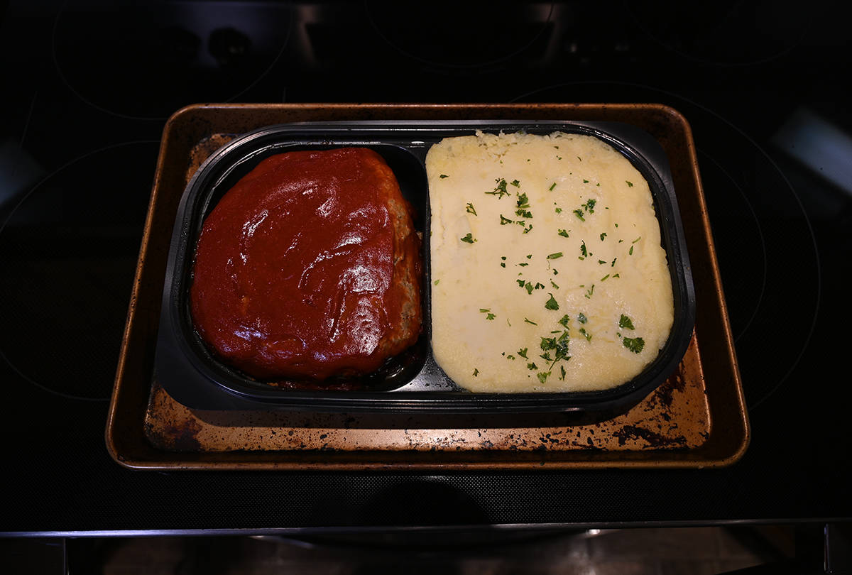 Top down image of the meatloaf and mashed potatoes tray on a baking sheet after being cooked.