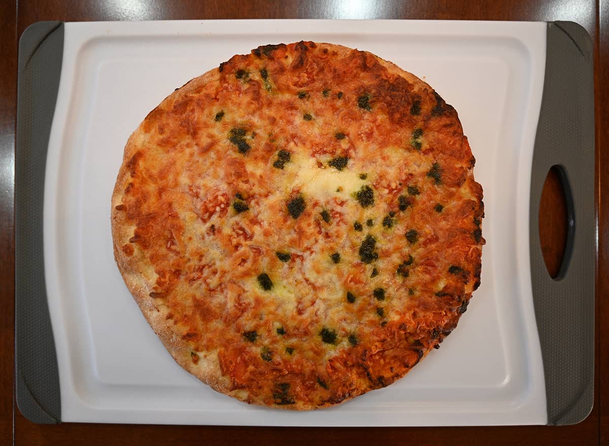 Top down image of one cooked pizza on a cutting board.