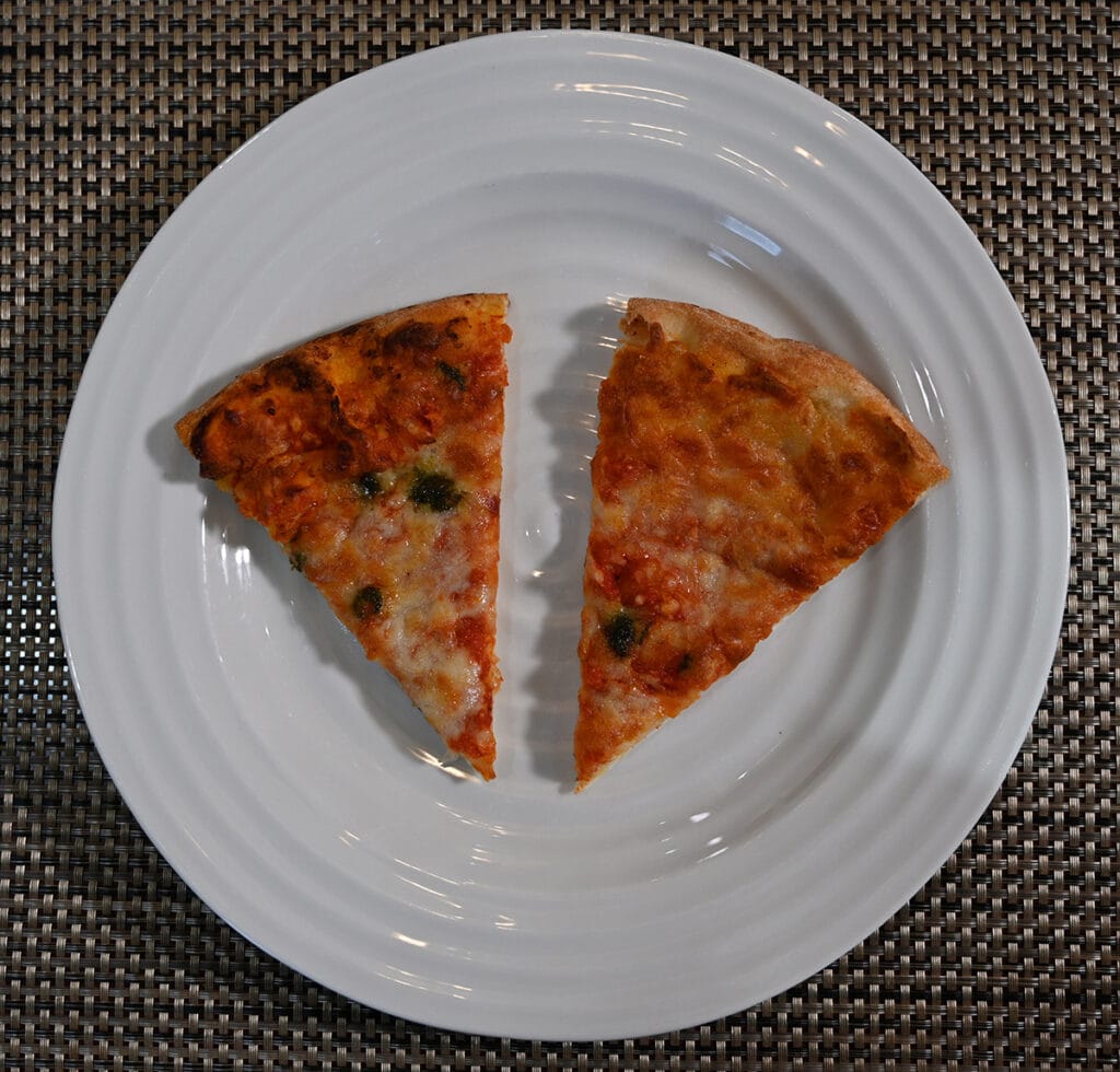 Top down image of two slices of pizza served on a white plate.