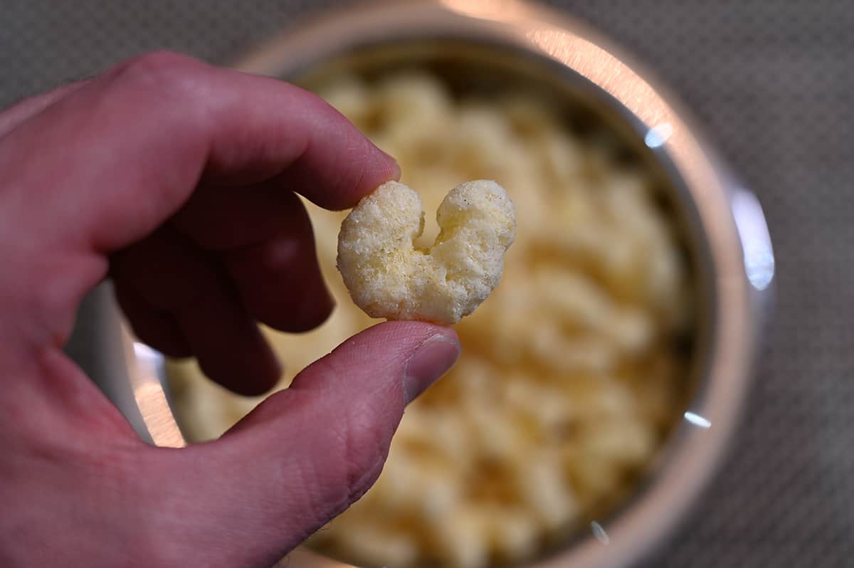 Closeup image of a hand holding one Pirate's Booty puff close to the camera.