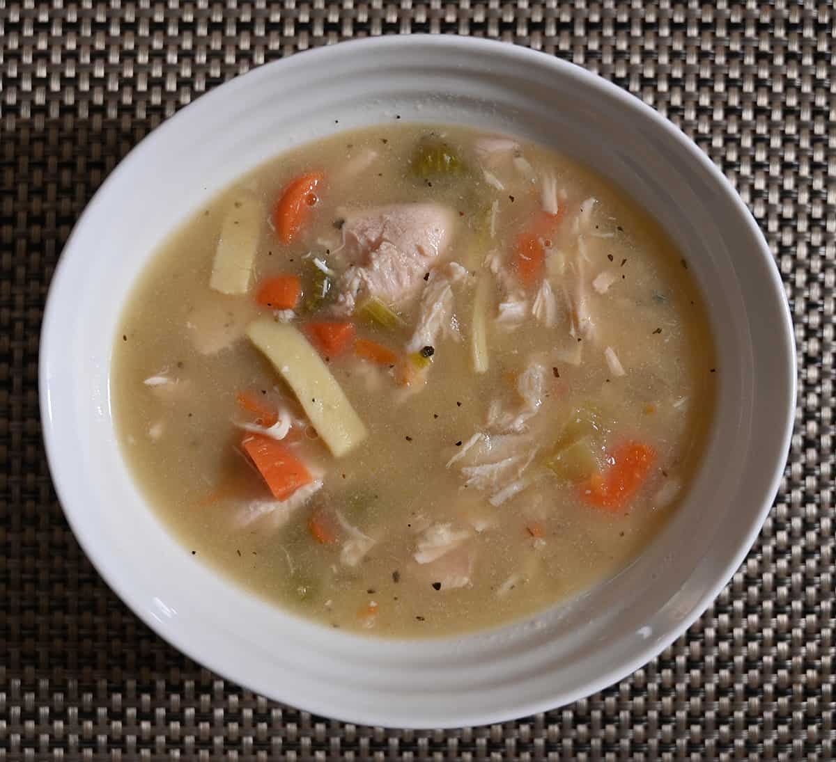 Closeup top down image of a bowl of Costco chicken noodle soup.