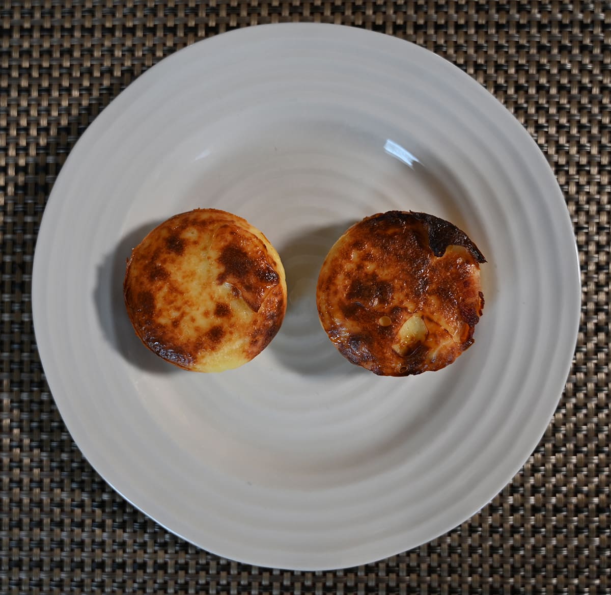 Top down image of two air fried egg bites sitting on a plate.