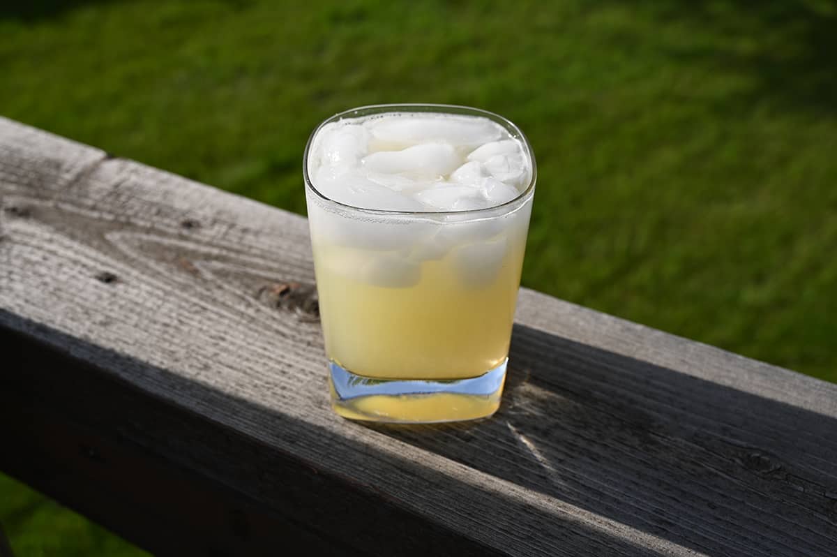 Image of a margarita with ice in it sitting outside on a deck.