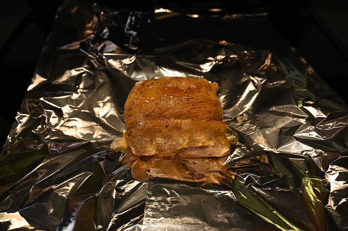 Sideview image of the turkey breast sitting on a stovetop on some foil, prior to being baked.