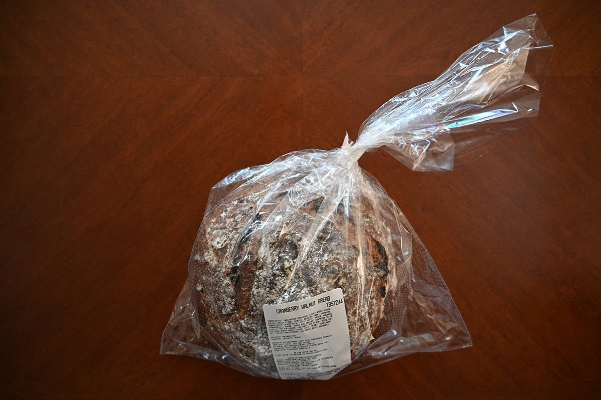 Top down image of a package of Costco Kirkland Signature Cranberry Walnut Bread sitting unopened on a table.
