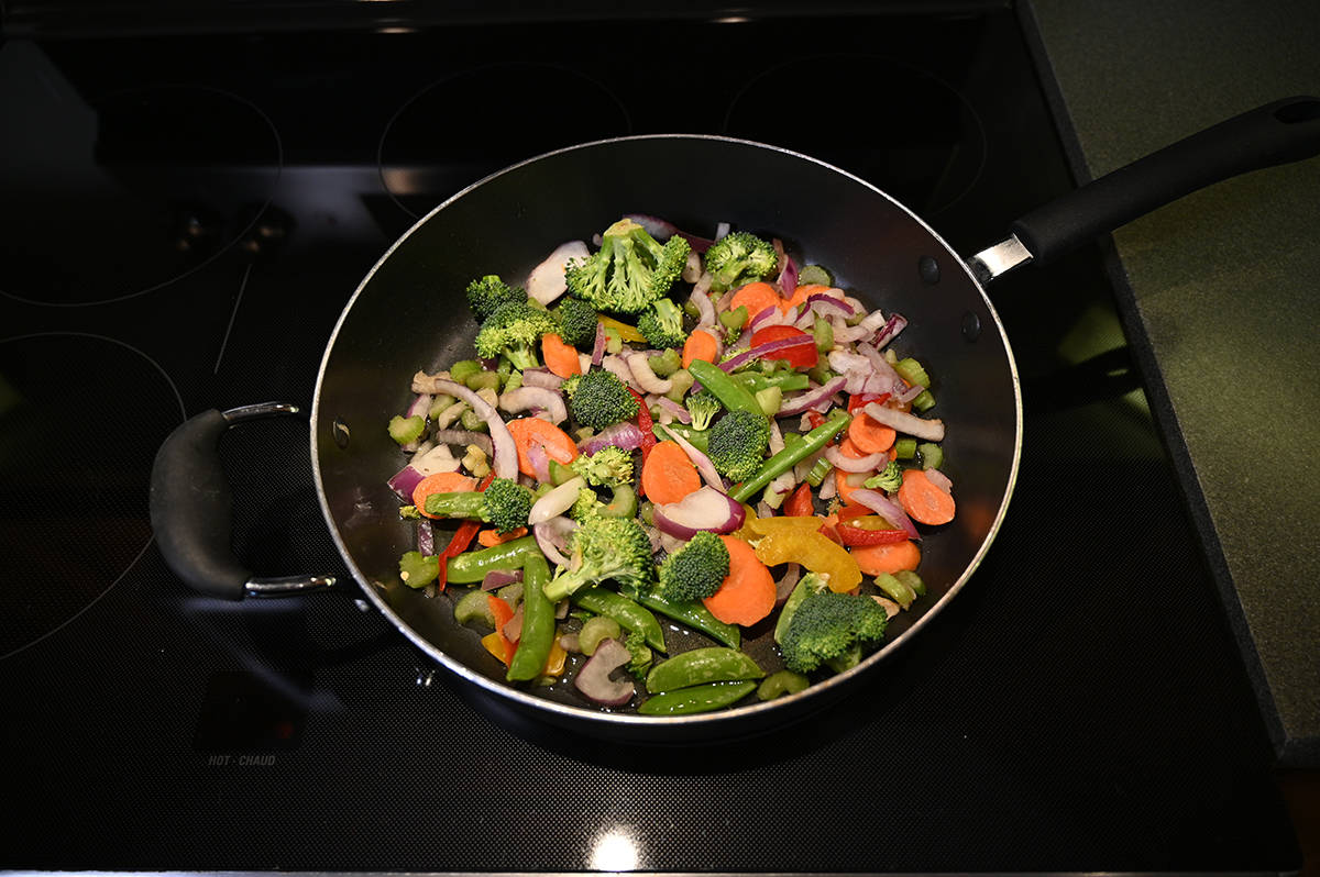 Top down image of the vegetables from the yakisoba being cooked in a frying pan on the stovetop.