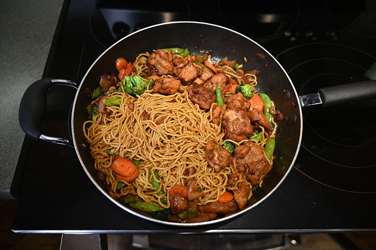 Top down image of a pan on the stovetop with prepared yakisoba in it.